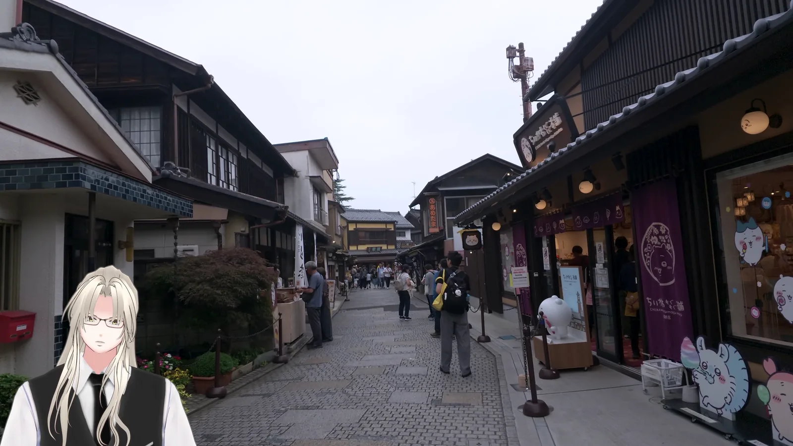 菓子屋横丁の石畳の通り。両側に木造の商店が並び、観光客が歩いている。