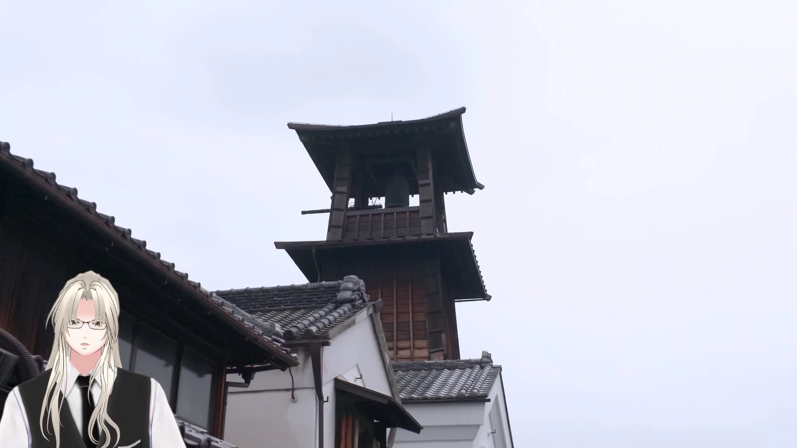 蔵造りの屋根越しに見える時の鐘の鐘楼。最上層に鐘が下がっているのが見える。