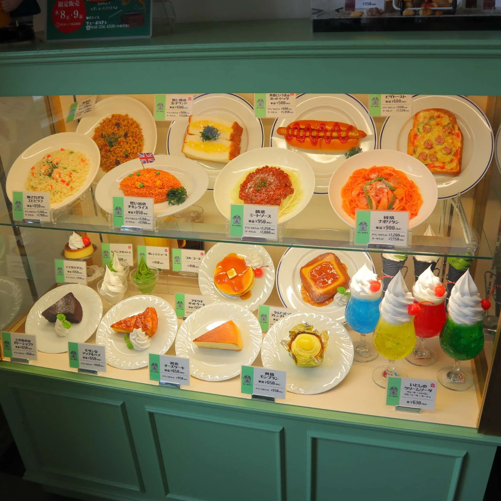 喫茶店の食品サンプルケース。ナポリタン、ピザトースト、プリンアラモード、クリームソーダなどが並ぶ。