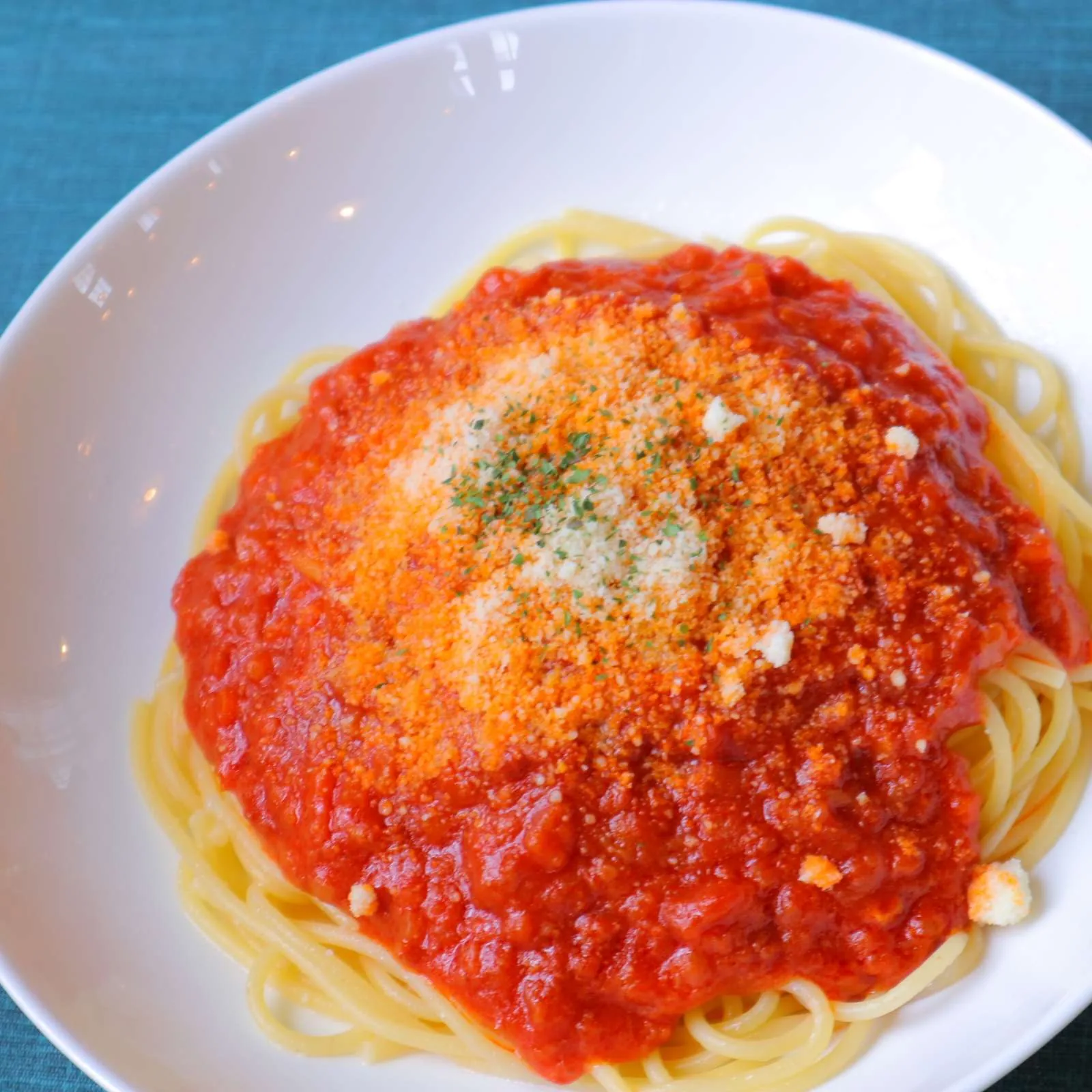 ミートソースのスパゲッティ。粉チーズとパセリがかかっている。