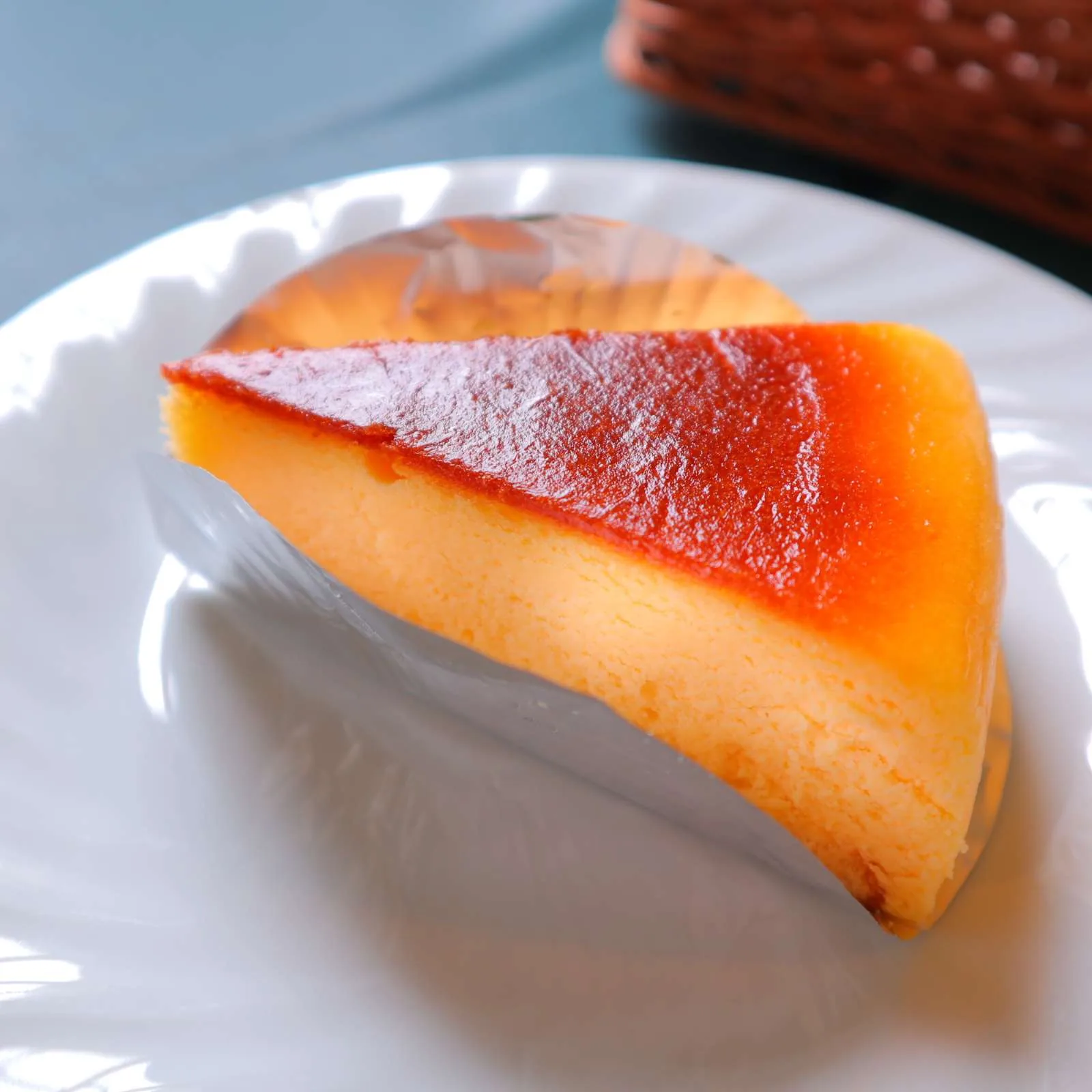 白い皿に盛られたベイクドチーズケーキ。表面がこんがりと焼けている。