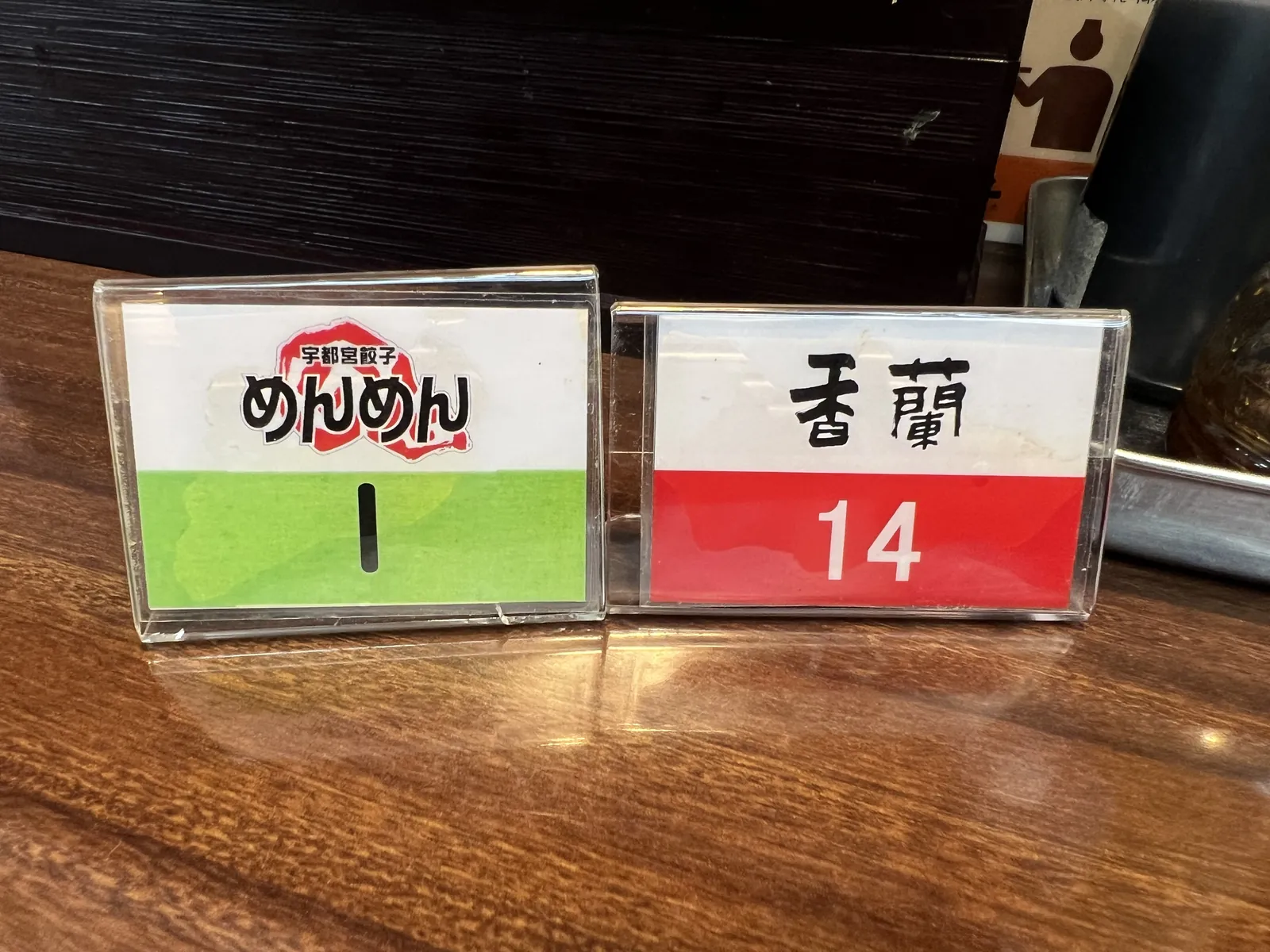 テーブルに置かれた2枚の番号札。「めんめん」と「香蘭」の店名が入っている。
